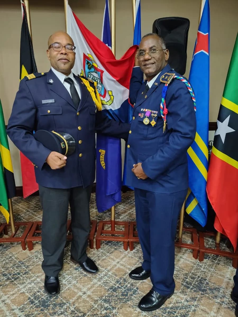 Two senior fire officers in dress uniform with Caribbean flags